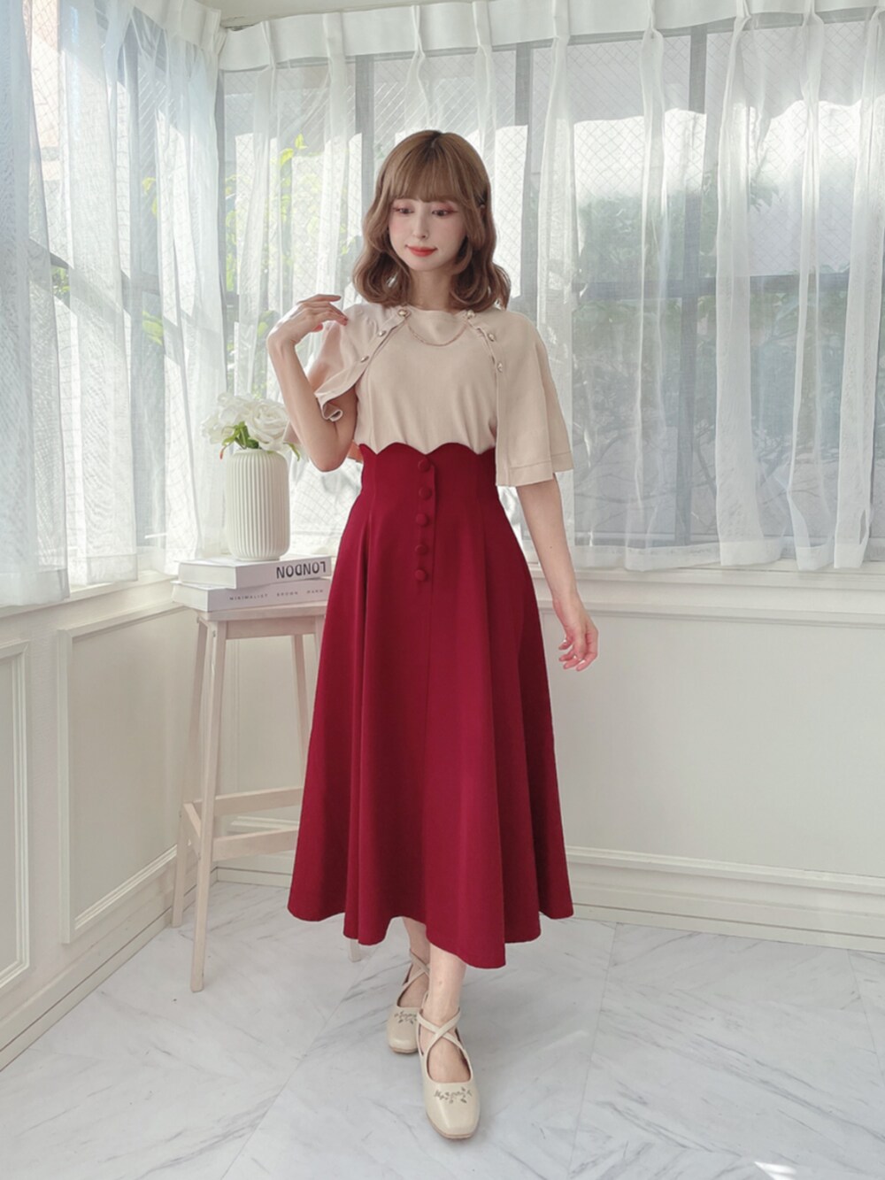 レッド系のスカートを着用したレディースの夏コーディネートの2枚目の写真
