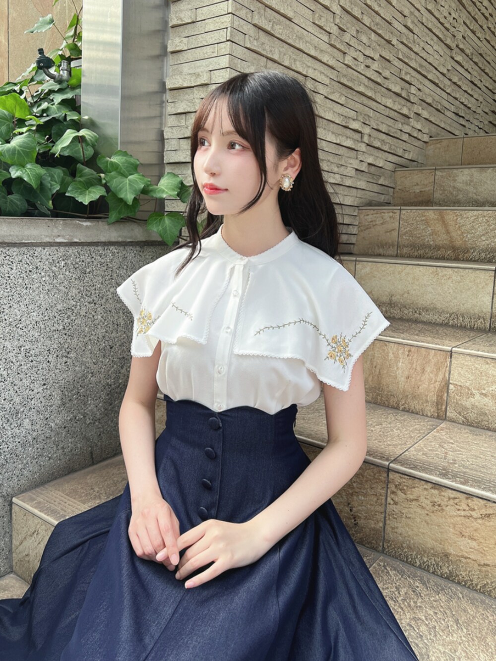 ブラウン系のパンプス、ホワイト系のシャツ/ブラウス、ブルー系のデニムスカートを着用したレディースの夏コーディネートの3枚目の写真