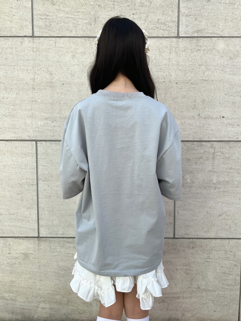 ホワイト系のスカート、ホワイト系のサンダル、グレー系のTシャツ/カットソーを着用したレディースの夏コーディネートの3枚目の写真