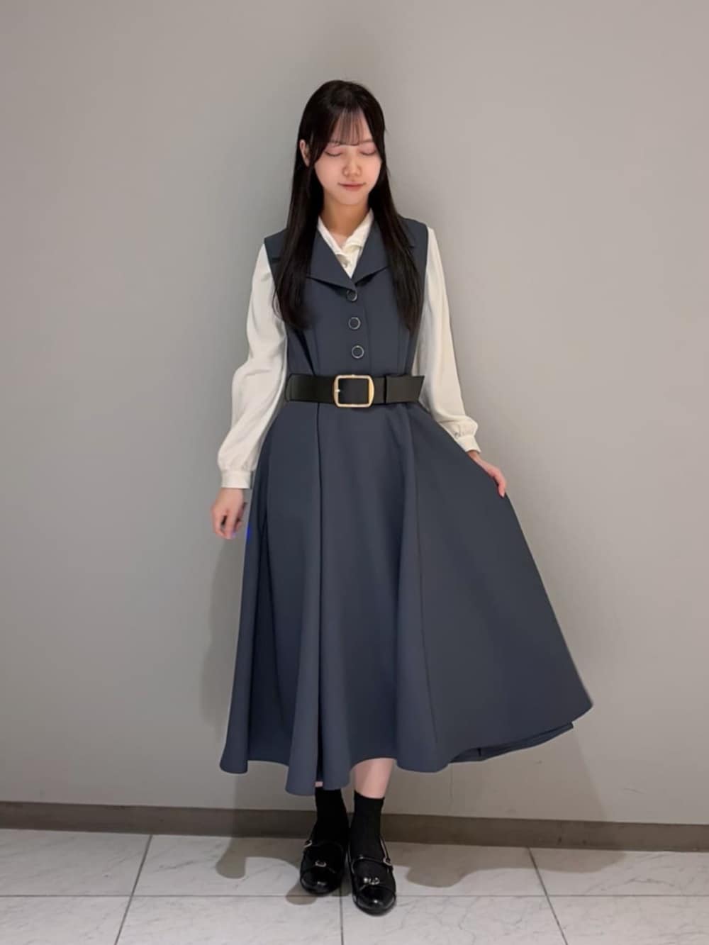 ブラック系のパンプス、ホワイト系のシャツ/ブラウス、グレー系のワンピースを着用したレディースの冬コーディネートの3枚目の写真