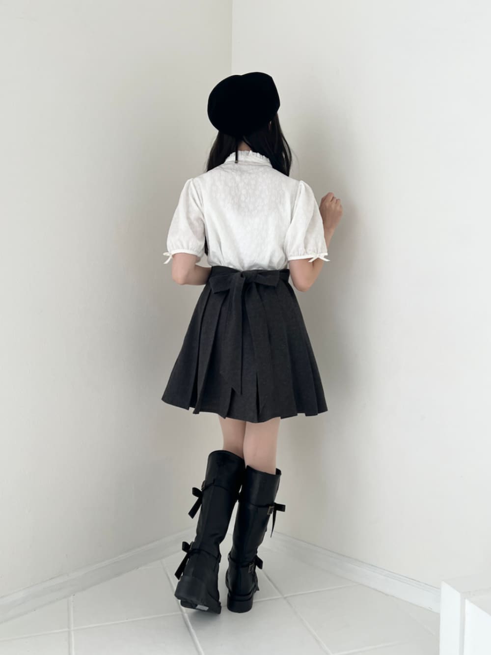 ホワイト系のシャツ/ブラウス、グレー系のジャンパースカート、ブラック系のブーツを着用したレディースの秋コーディネートの4枚目の写真