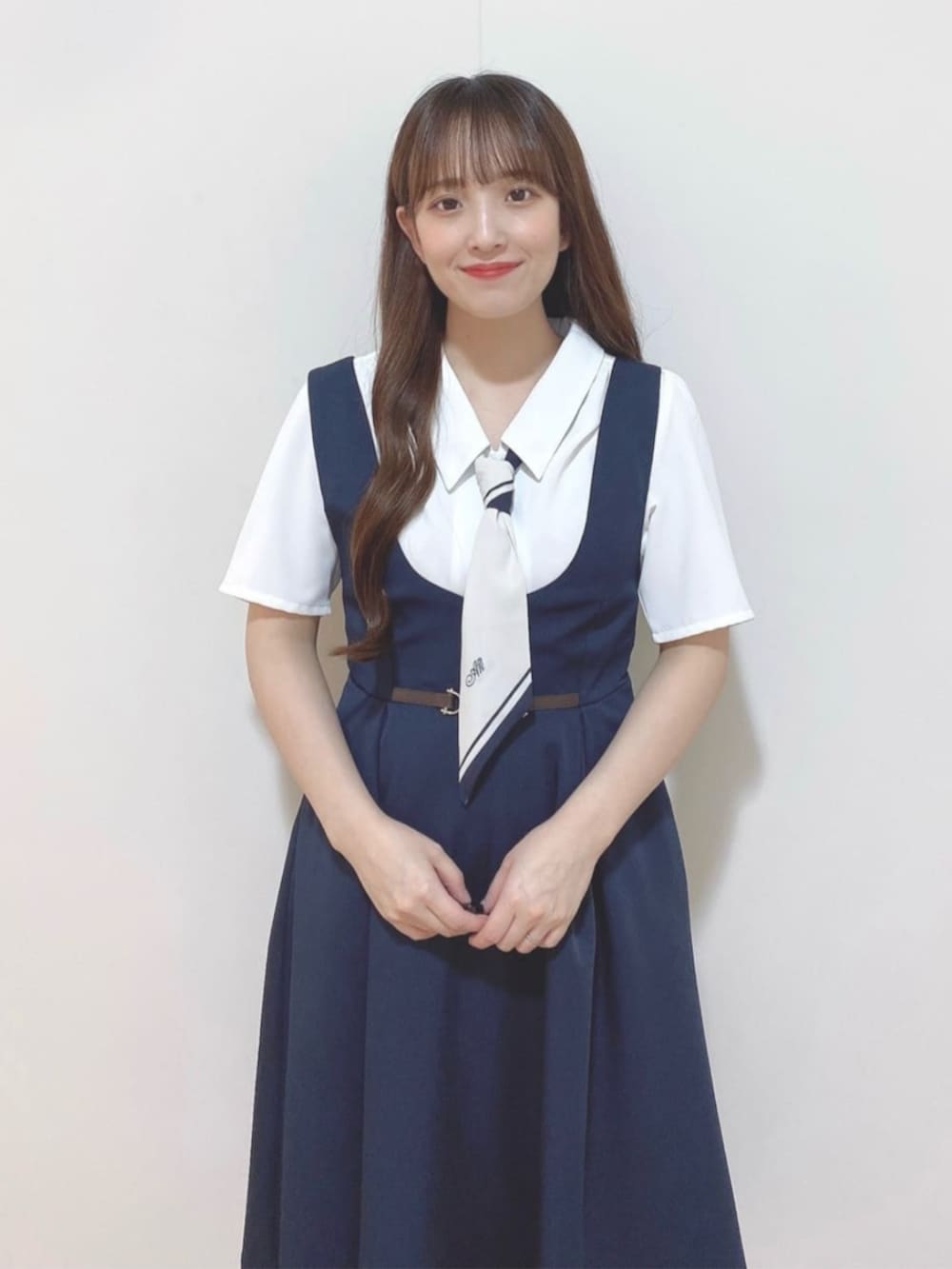 ホワイト系のシャツ/ブラウス、ブルー系のジャンパースカート、ホワイト系のサンダルを着用したレディースの夏コーディネートの3枚目の写真