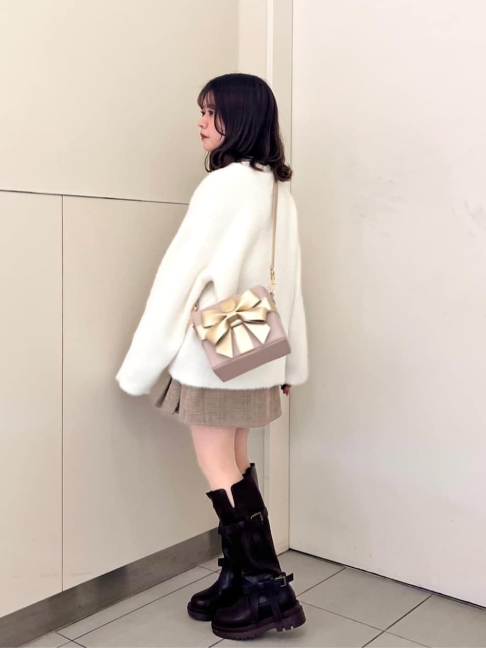 ホワイト系のTシャツ/カットソー、ブラウン系のブーツ、ホワイト系のカーディガン/ボレロを着用したレディースの秋コーディネートの3枚目の写真