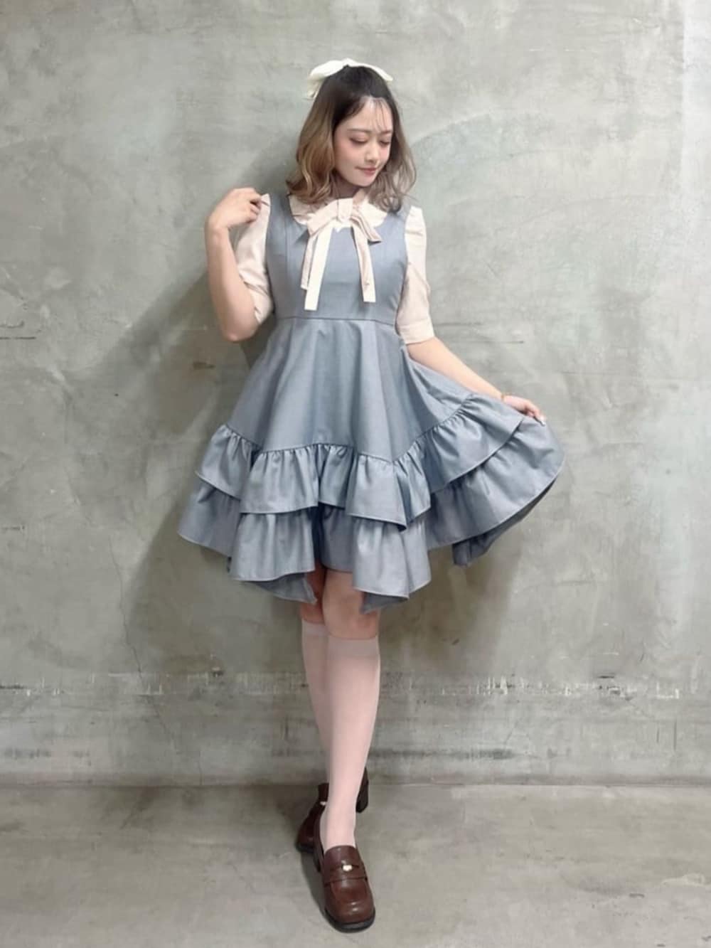 ブラウン系のローファー、ピンク系のシャツ/ブラウス、グレー系のジャンパースカートを着用したレディースの春コーディネートの2枚目の写真