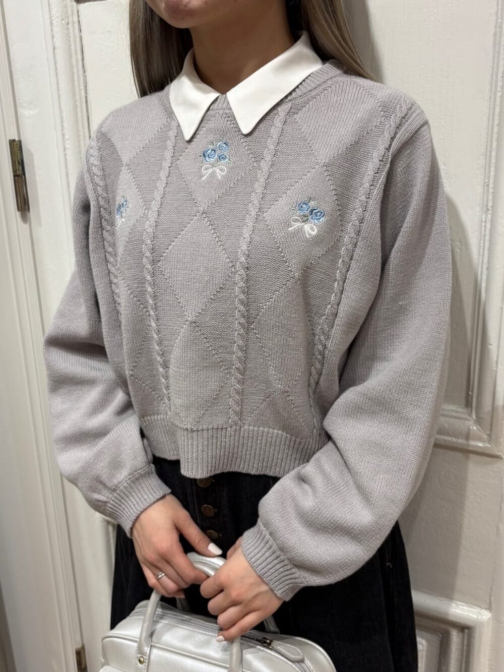 シルバー系のハンドバッグ、グレー系のスニーカー、ホワイト系のシャツ/ブラウスを着用したレディースの冬コーディネートの2枚目の写真