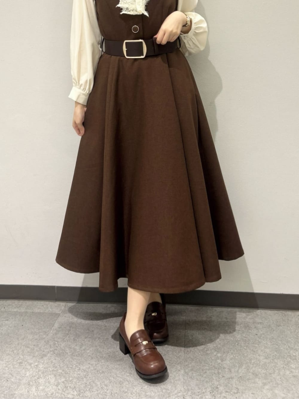 レッド系のハンドバッグ、ブラウン系のローファー、ホワイト系のシャツ/ブラウスを着用したレディースの秋コーディネートの3枚目の写真