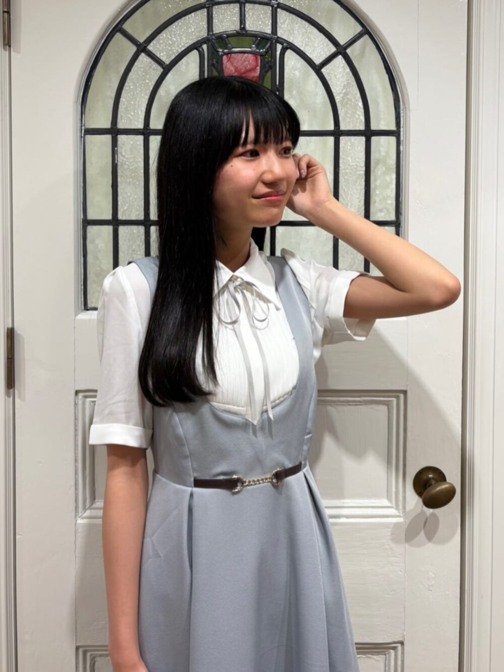ブラック系のパンプス、ブラック系のハンドバッグ、ホワイト系のシャツ/ブラウスを着用したレディースの夏コーディネートの3枚目の写真