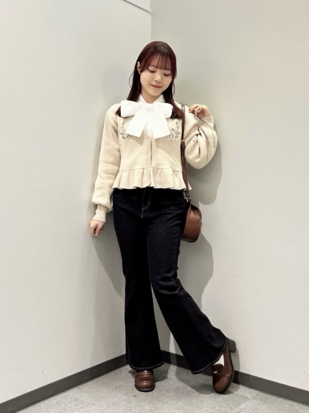 ブラウン系のローファー、ブラック系のデニムパンツ、ブラウン系のショルダーバッグを着用したレディースの冬コーディネートの2枚目の写真