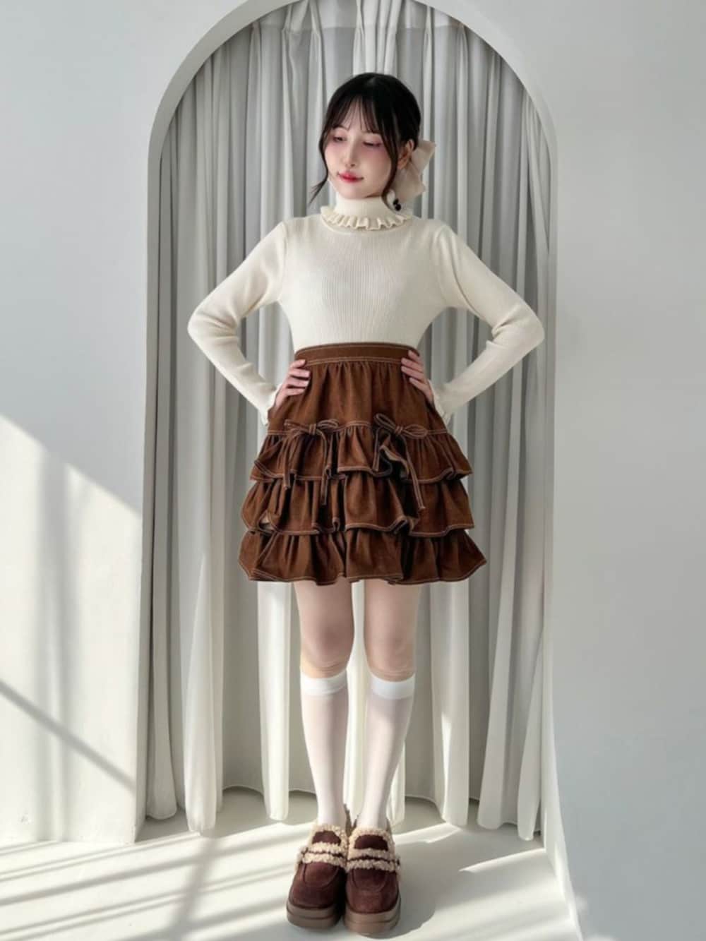 ブラウン系のスカート、ブラウン系のモカシン/デッキシューズ、ホワイト系のニット/セーターを着用したレディースの秋コーディネートの2枚目の写真