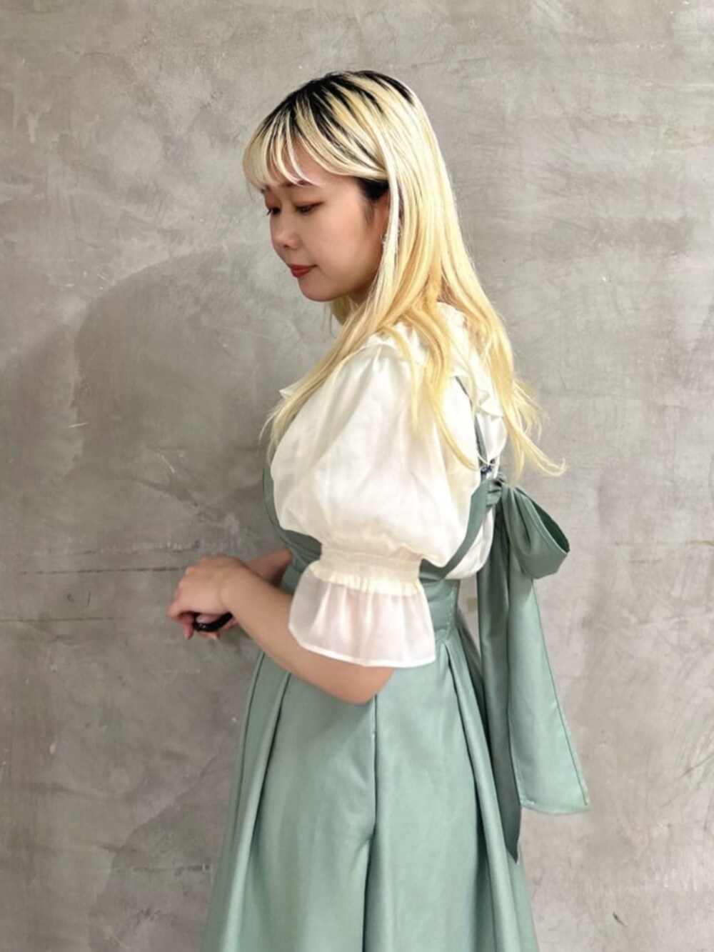 ブラック系のパンプス、ホワイト系のシャツ/ブラウス、グリーン系のワンピースを着用したレディースの夏コーディネートの3枚目の写真