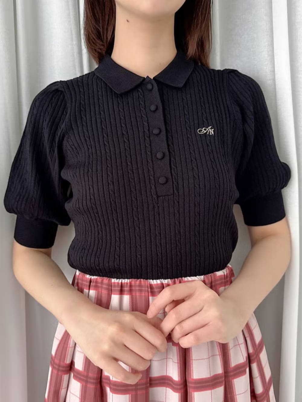 ブラック系のパンプス、レッド系のハンドバッグ、ブラック系のポロシャツを着用したレディースの夏コーディネートの2枚目の写真