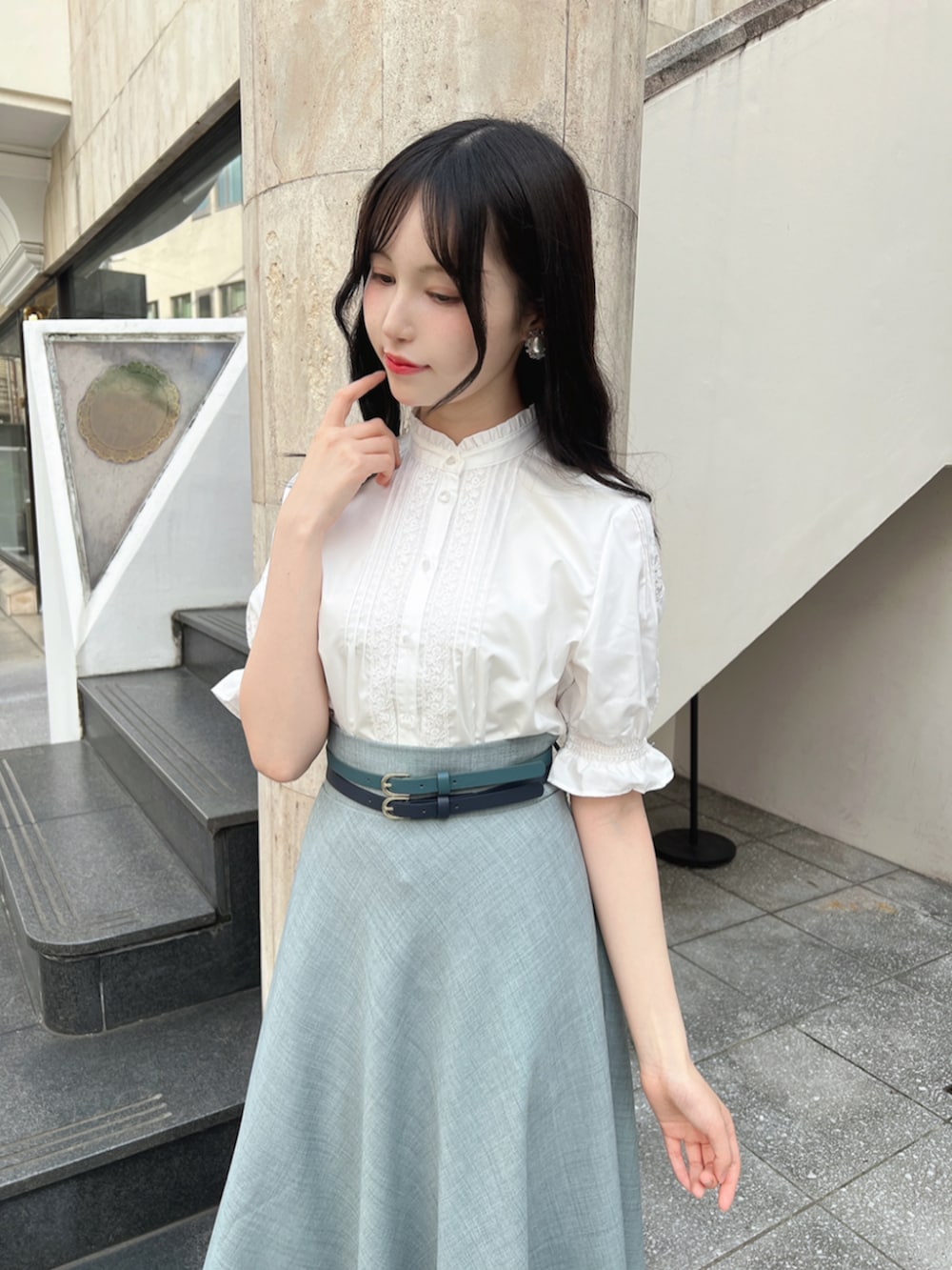ブラウン系のパンプス、ホワイト系のシャツ/ブラウス、ブルー系のスカートを着用したレディースの春コーディネートの2枚目の写真