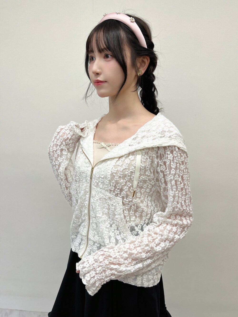 ホワイト系のパーカー、ブラック系のスカート、ホワイト系のタンクトップを着用したレディースの春コーディネートの2枚目の写真