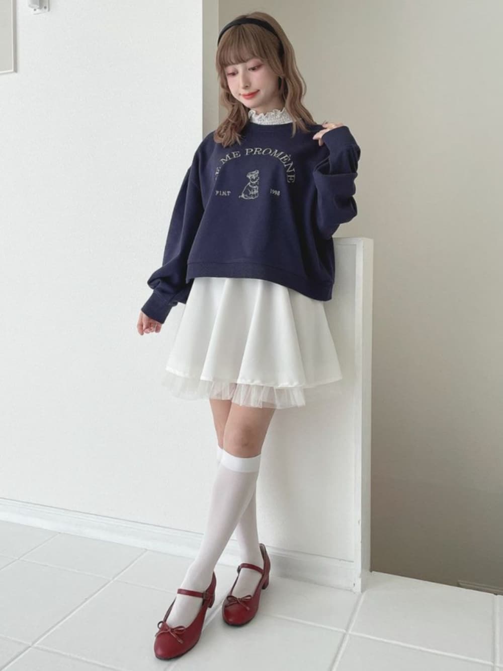 ホワイト系のスカート、ホワイト系のTシャツ/カットソー、レッド系のバレエシューズを着用したレディースの冬コーディネートの2枚目の写真