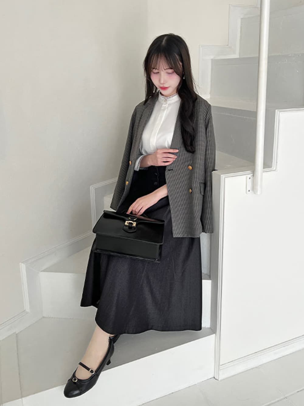 ブラック系のハンドバッグ、ブラック系のデニムスカート、ホワイト系のシャツ/ブラウスを着用したレディースの秋コーディネートの3枚目の写真