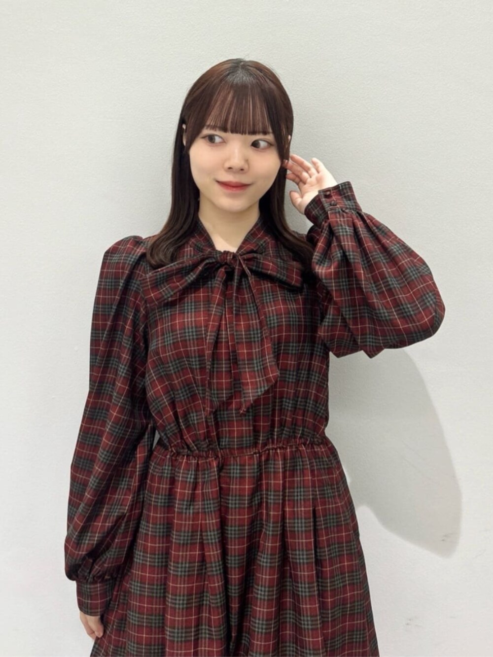 ブラウン系のショルダーバッグ、ブラウン系のブーツ、レッド系のワンピースを着用したレディースの秋コーディネートの4枚目の写真