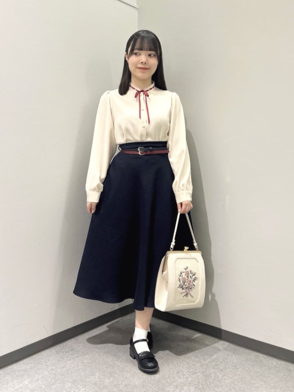 ピンク系のシャツ/ブラウス、ブラック系のローファー、ホワイト系のハンドバッグを着用したレディースの冬コーディネートの2枚目の写真