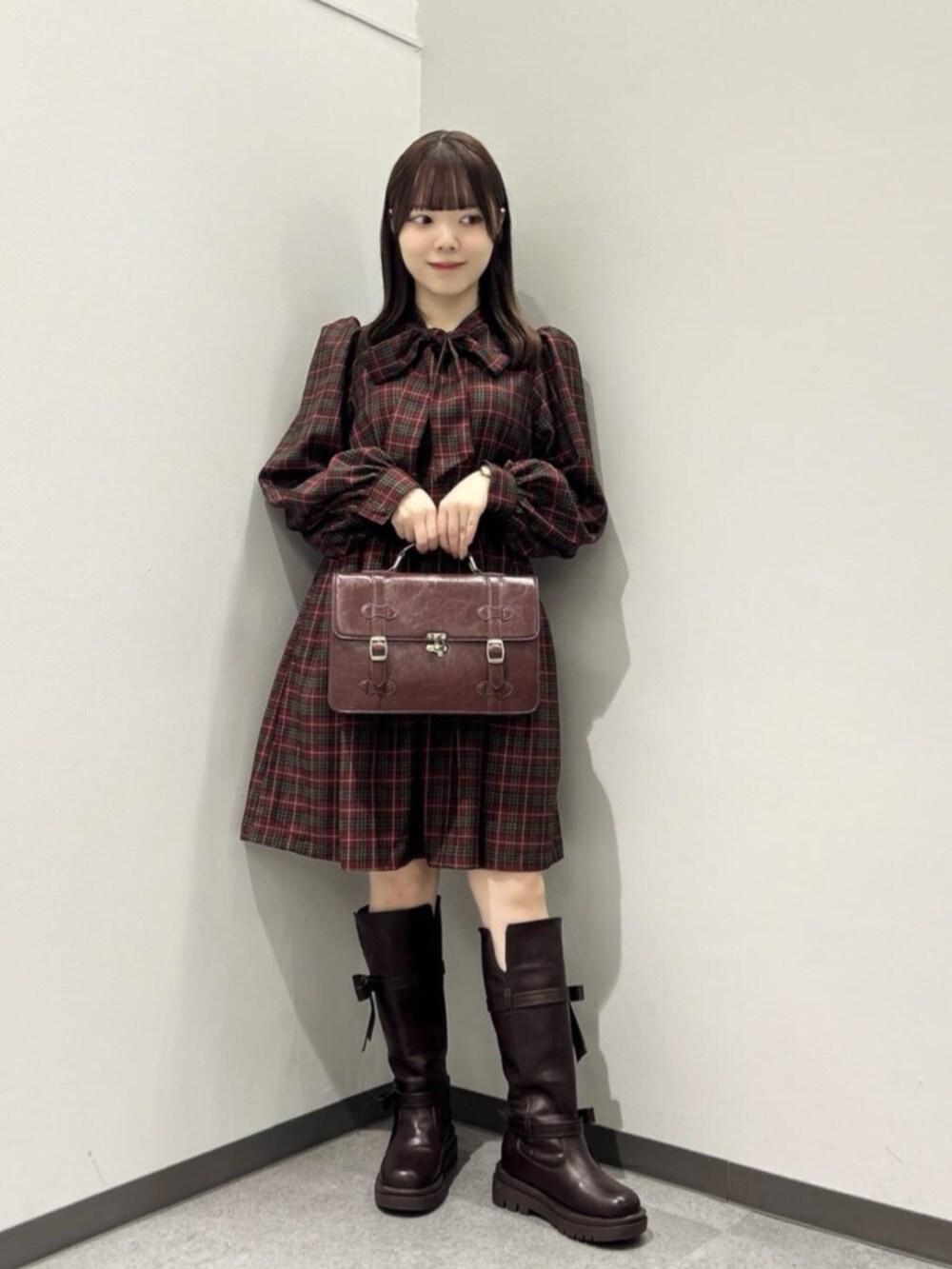 ブラウン系のショルダーバッグ、ブラウン系のブーツ、レッド系のワンピースを着用したレディースの秋コーディネートの2枚目の写真