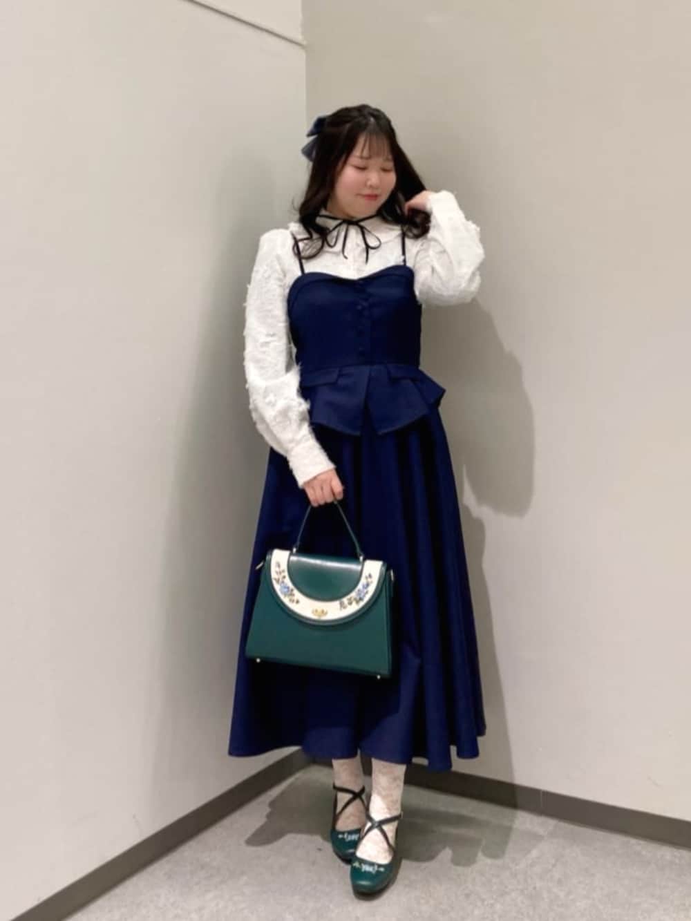 ブルー系のハンドバッグ、ブルー系のパンプス、ホワイト系のシャツ/ブラウスを着用したレディースの冬コーディネートの2枚目の写真