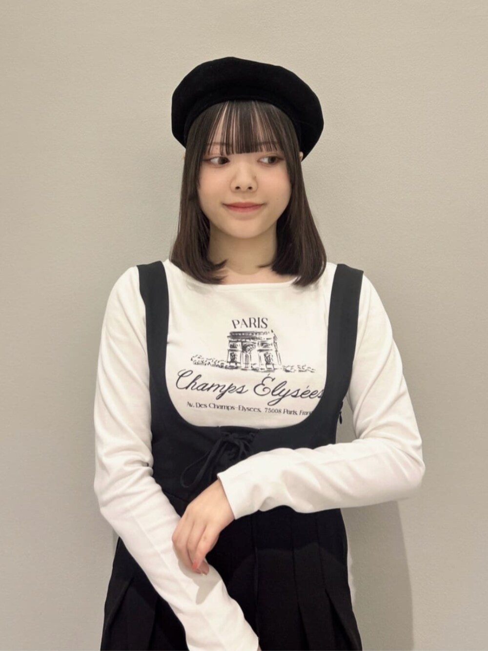 イエロー系のハンドバッグ、ホワイト系のTシャツ/カットソー、ブラック系のブーツを着用したレディースの冬コーディネートの2枚目の写真