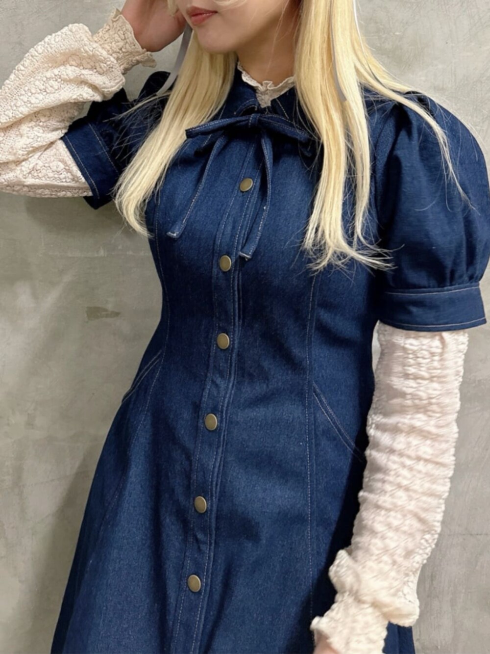 ホワイト系のスニーカー、ホワイト系のハンドバッグ、ブルー系のワンピースを着用したレディースの春コーディネートの2枚目の写真