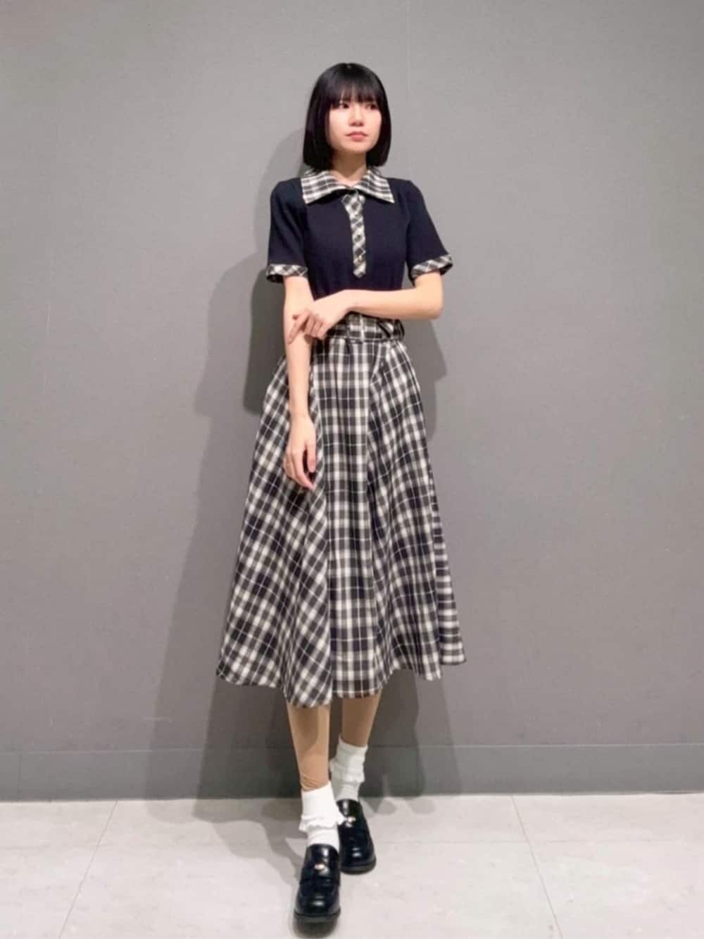 ブラック系のローファー、ブラック系のポロシャツ、ブラック系のスカートを着用したレディースの春コーディネートの3枚目の写真