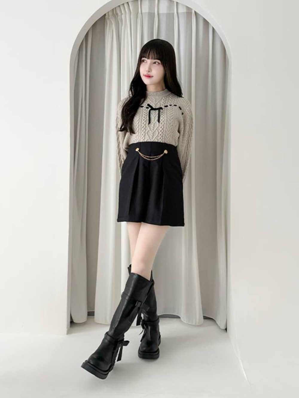ブラック系のブーツ、ブラック系のその他パンツ、グレー系のニット/セーターを着用したレディースの秋コーディネートの2枚目の写真