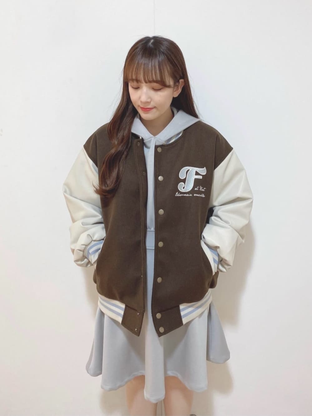 グレー系のワンピース、ブラウン系のスタジャン、ブラック系のレインシューズを着用したレディースの冬コーディネートの2枚目の写真