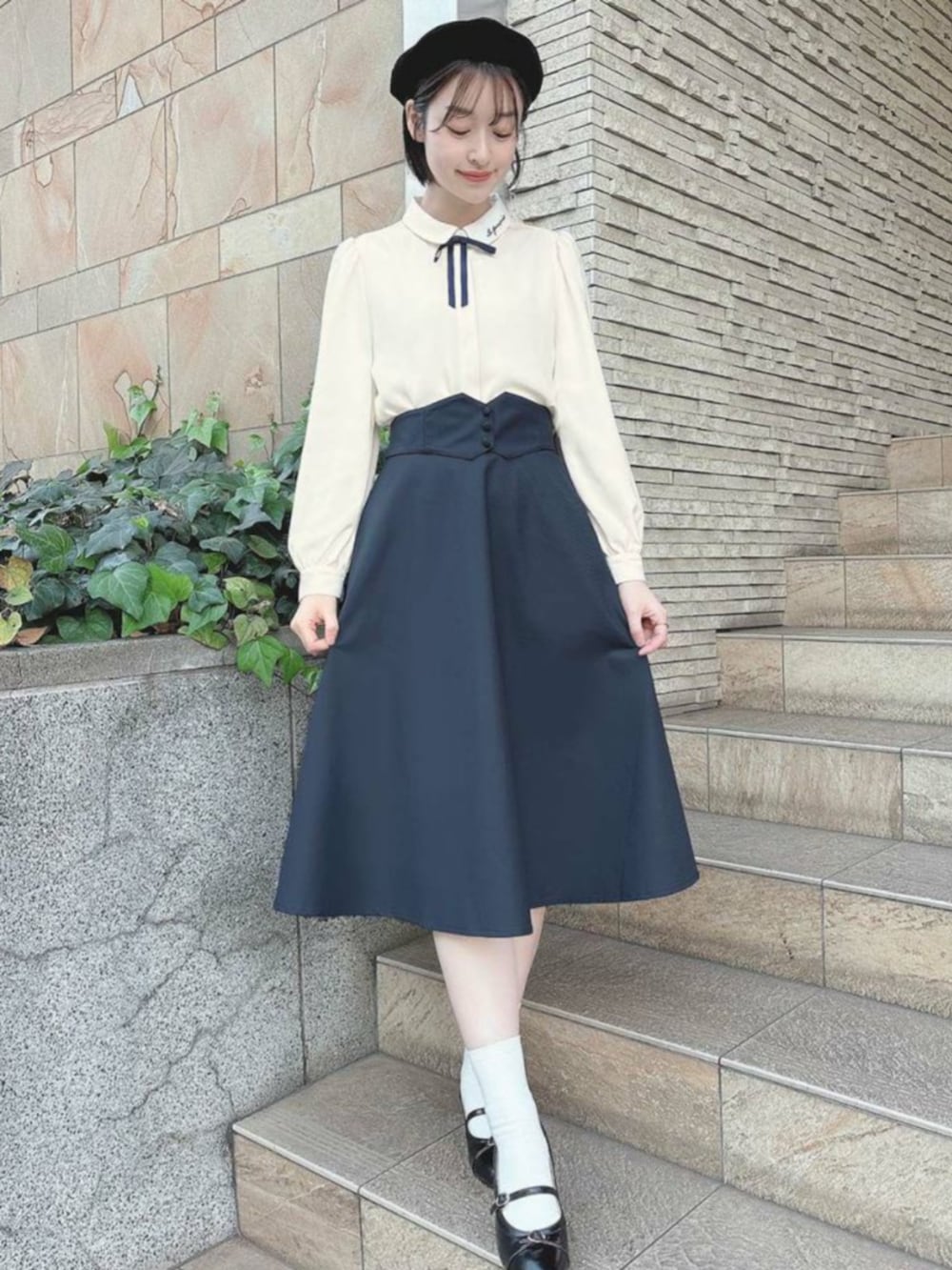 ホワイト系のシャツ/ブラウス、ブラック系のパンプス、ブルー系のスカートを着用したレディースの冬コーディネートの2枚目の写真