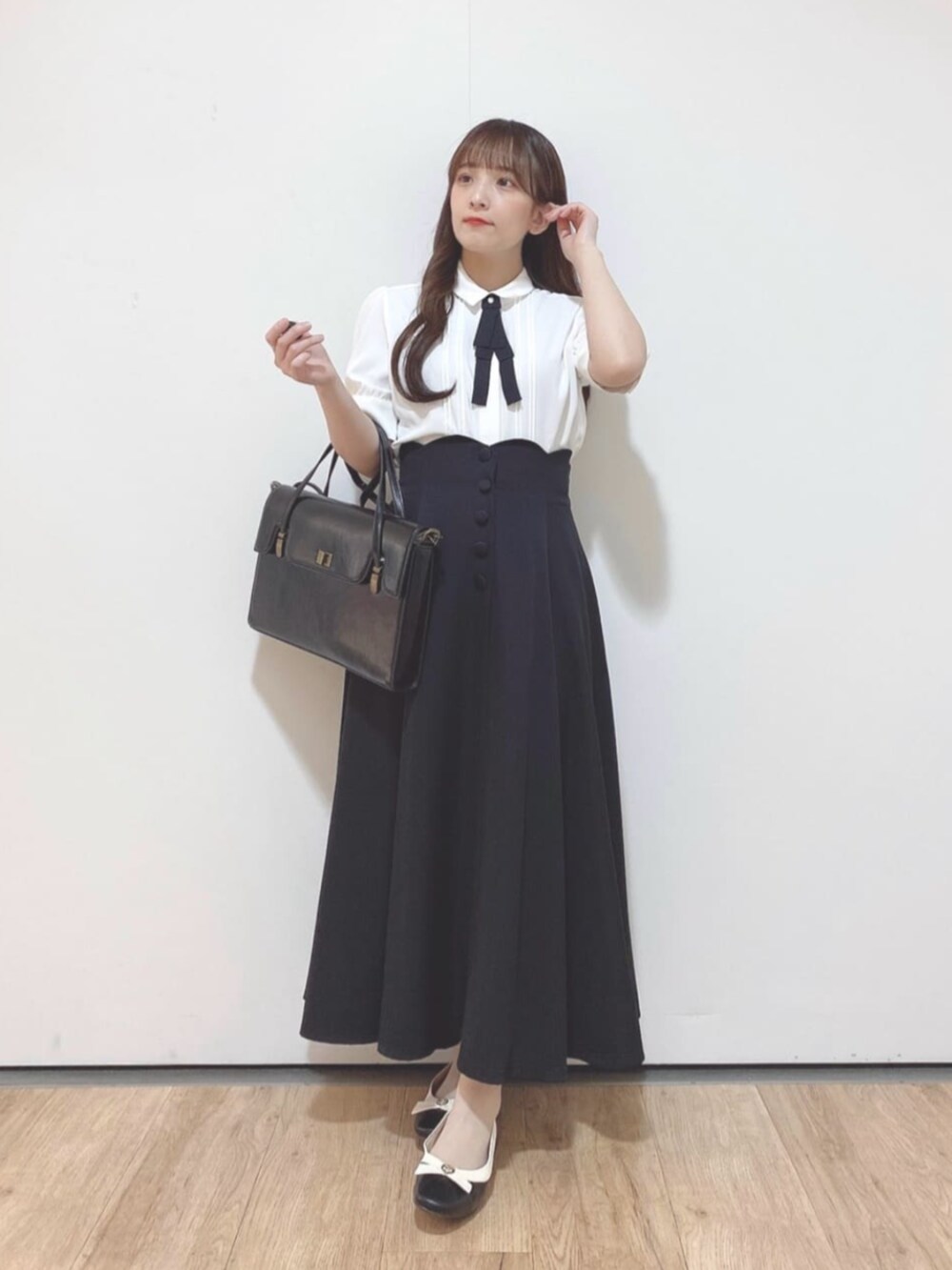 ブラック系のパンプス、ホワイト系のシャツ/ブラウス、ブラック系のスカートを着用したレディースの夏コーディネートの3枚目の写真