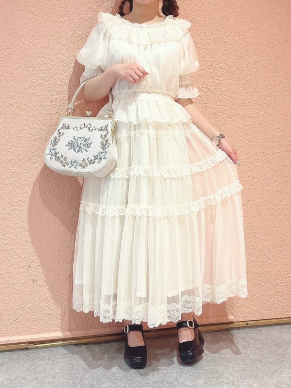 ホワイト系のシャツ/ブラウス、ブラウン系のパンプス、ホワイト系のハンドバッグを着用したレディースの夏コーディネートの2枚目の写真