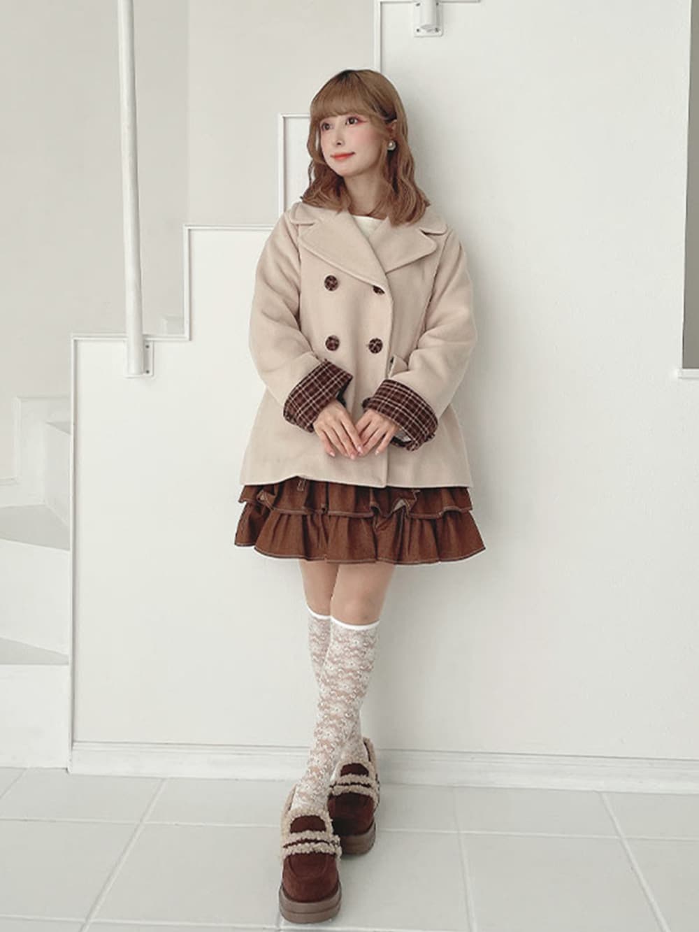 ブラウン系のスカート、ブラウン系のモカシン/デッキシューズ、ベージュ系のピーコートを着用したレディースの秋コーディネートの2枚目の写真