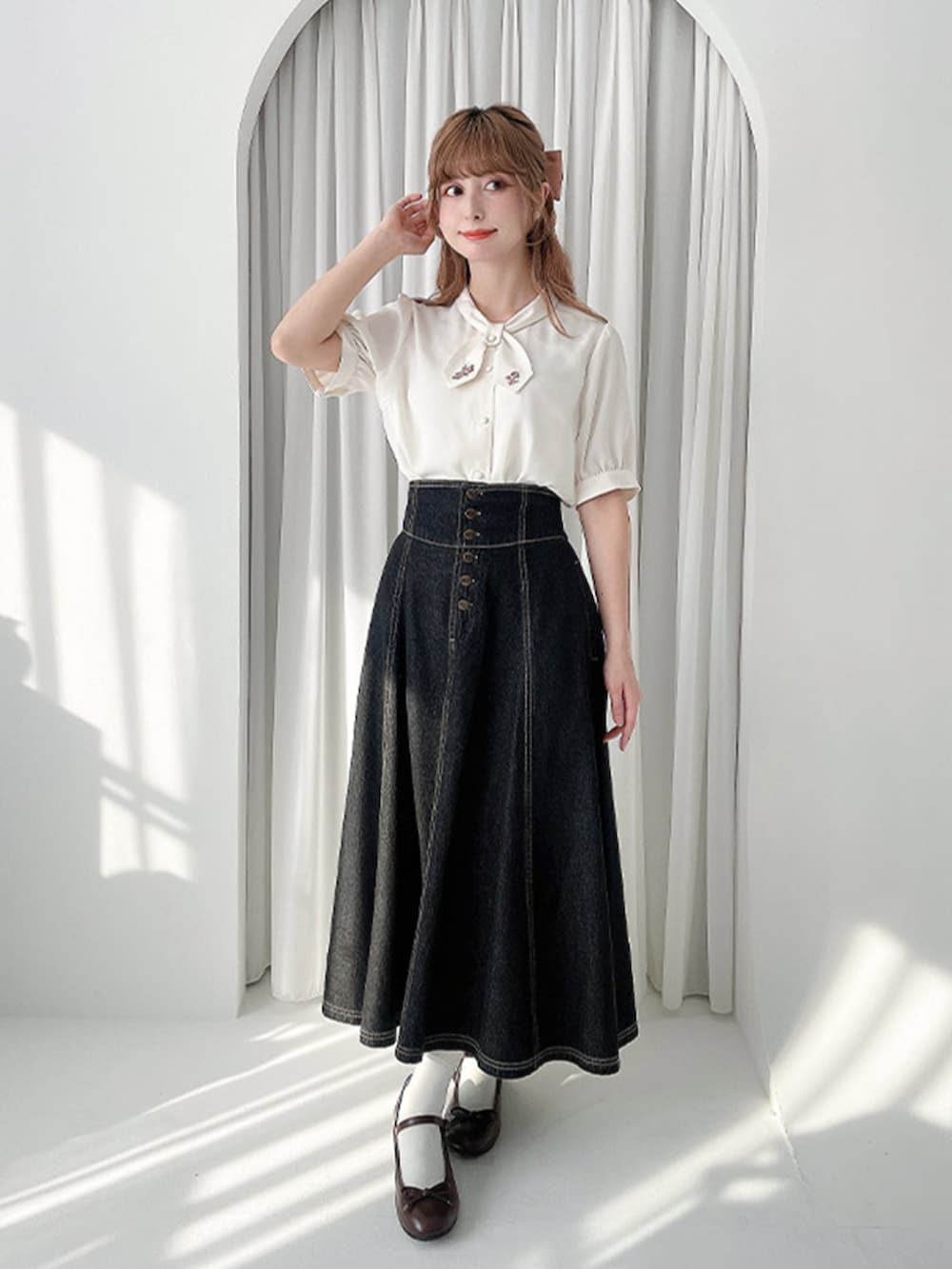 ブラック系のデニムスカート、ブラウン系のバレエシューズ、ピンク系のカーディガン/ボレロを着用したレディースの春コーディネートの3枚目の写真