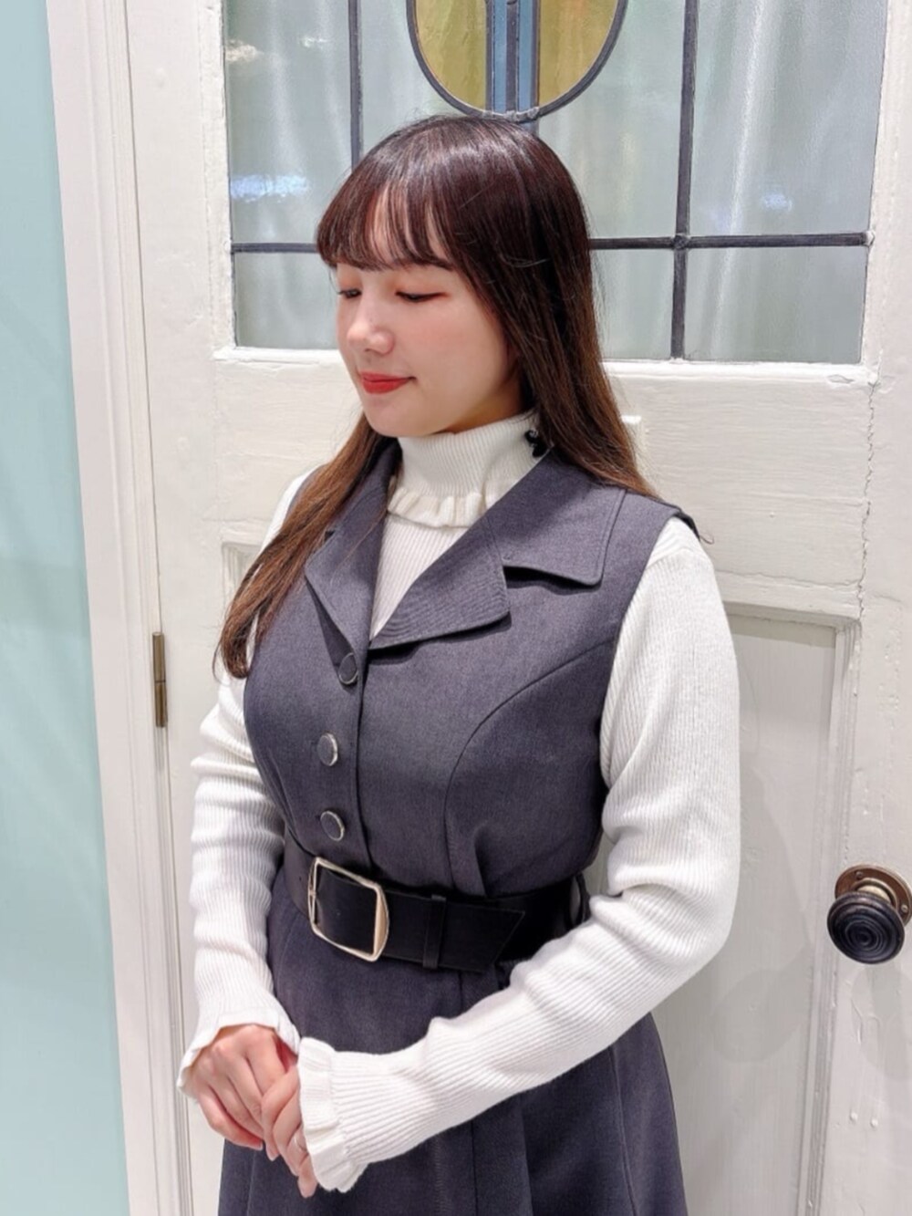 ブラック系のトートバッグ、ブルー系のパンプス、ホワイト系のニット/セーターを着用したレディースの秋コーディネートの2枚目の写真