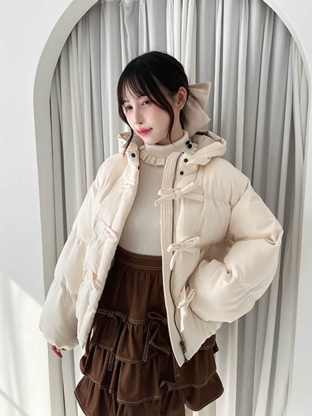 ホワイト系のダウンジャケット/コート、ブラウン系のスカート、ブラウン系のモカシン/デッキシューズを着用したレディースの秋コーディネートの3枚目の写真