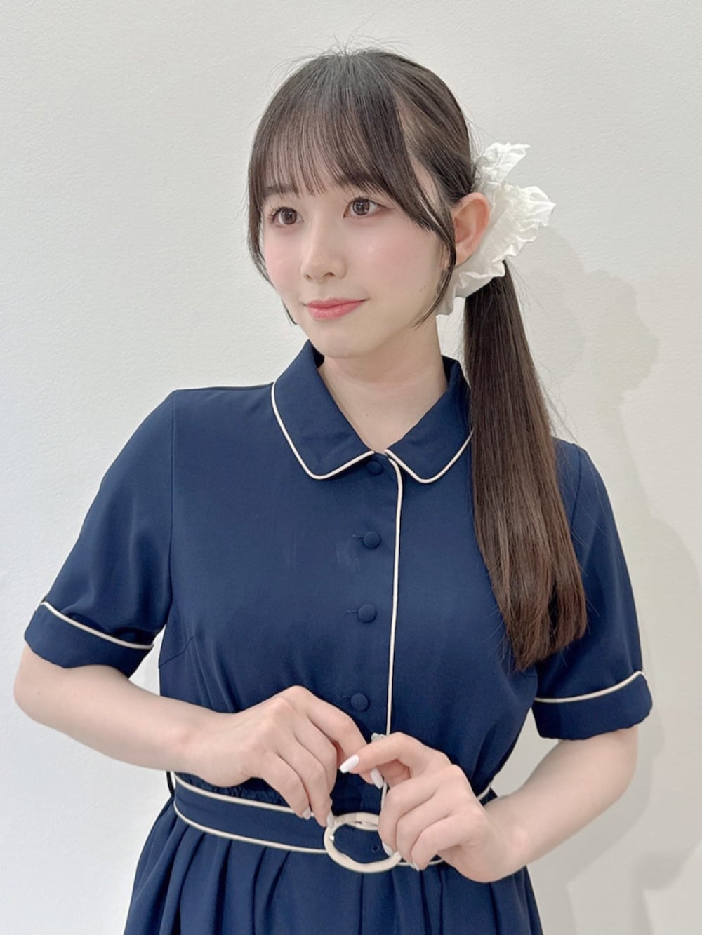ベージュ系のバレエシューズ、ホワイト系のハンドバッグ、ブルー系のワンピースを着用したレディースの春コーディネートの2枚目の写真