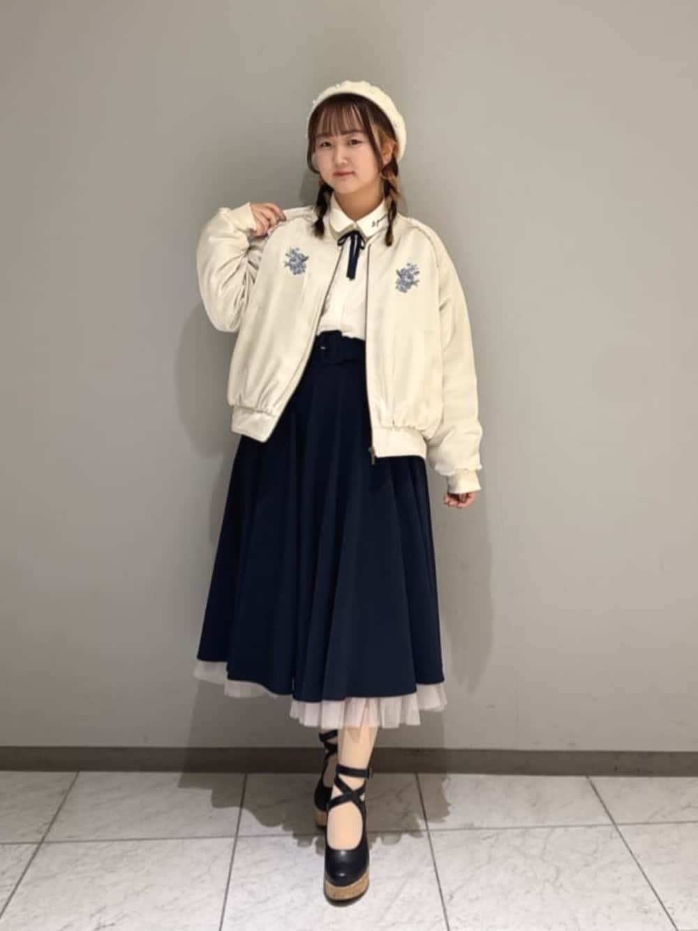 ホワイト系のシャツ/ブラウス、ブラック系のパンプス、ブルー系のスカートを着用したレディースの冬コーディネートの2枚目の写真