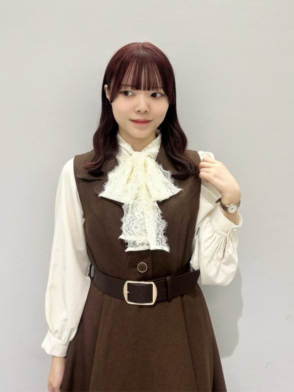 レッド系のハンドバッグ、ブラウン系のローファー、ホワイト系のシャツ/ブラウスを着用したレディースの秋コーディネートの2枚目の写真