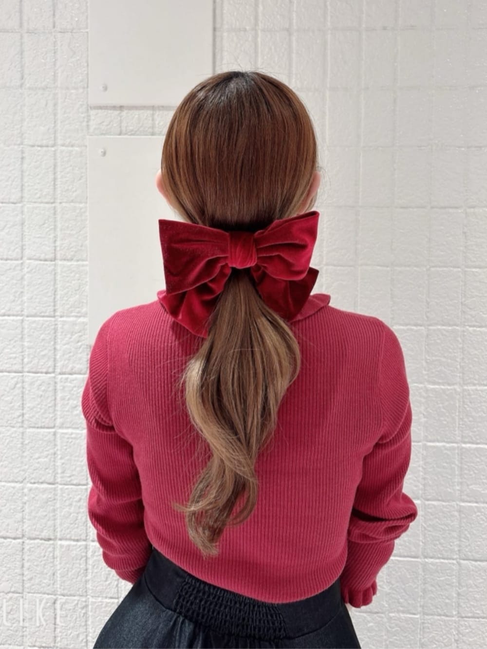 ブラック系のパンプス、ブラック系のデニムスカート、レッド系のハンドバッグを着用したレディースの冬コーディネートの3枚目の写真