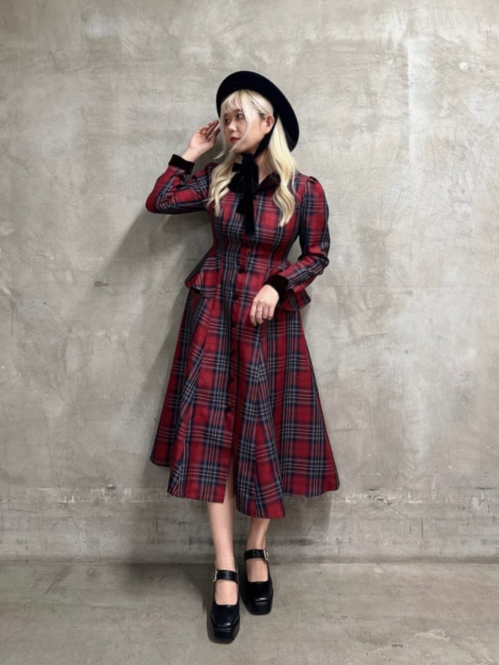 ブラック系のパンプス、レッド系のワンピース、ブラック系のハットを着用したレディースの秋コーディネートの2枚目の写真