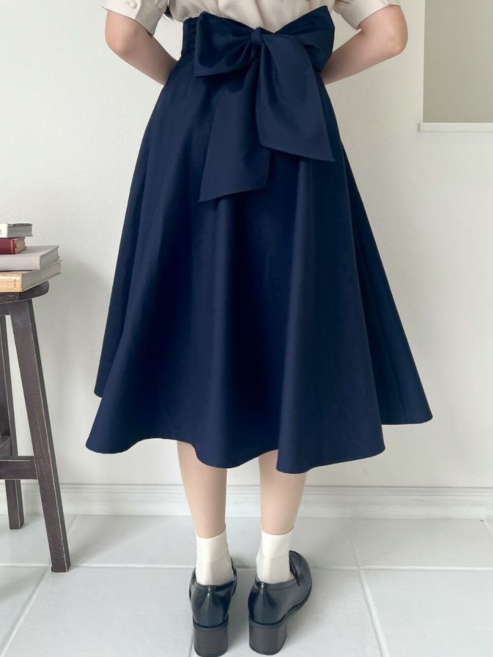 ブラック系のローファー、ベージュ系のシャツ/ブラウス、ブルー系のスカートを着用したレディースの秋コーディネートの2枚目の写真