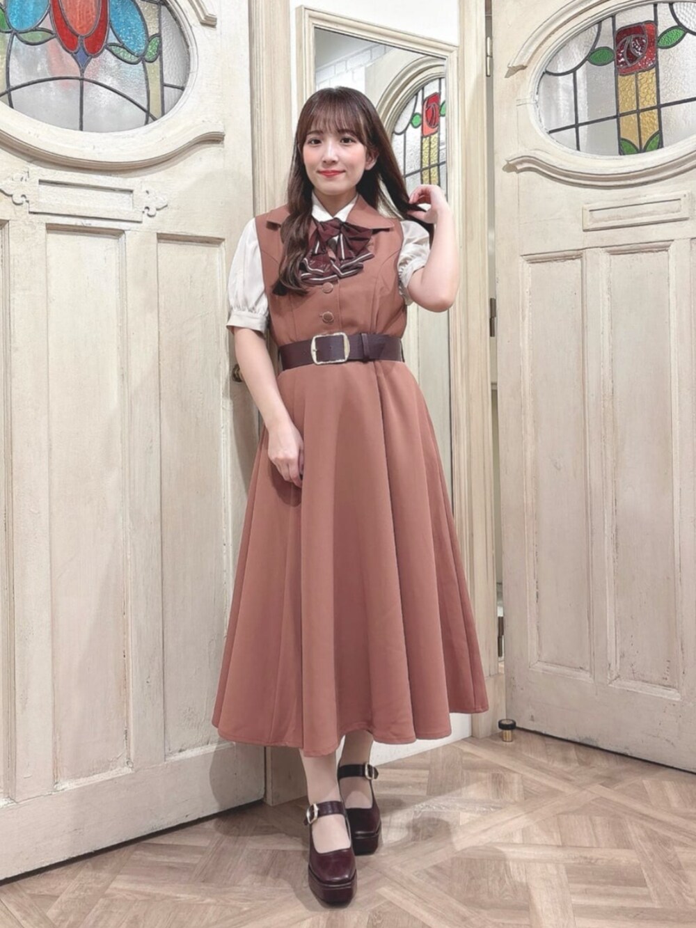 ブラウン系のパンプス、レッド系のワンピース、ベージュ系のシャツ/ブラウスを着用したレディースの秋コーディネートの3枚目の写真