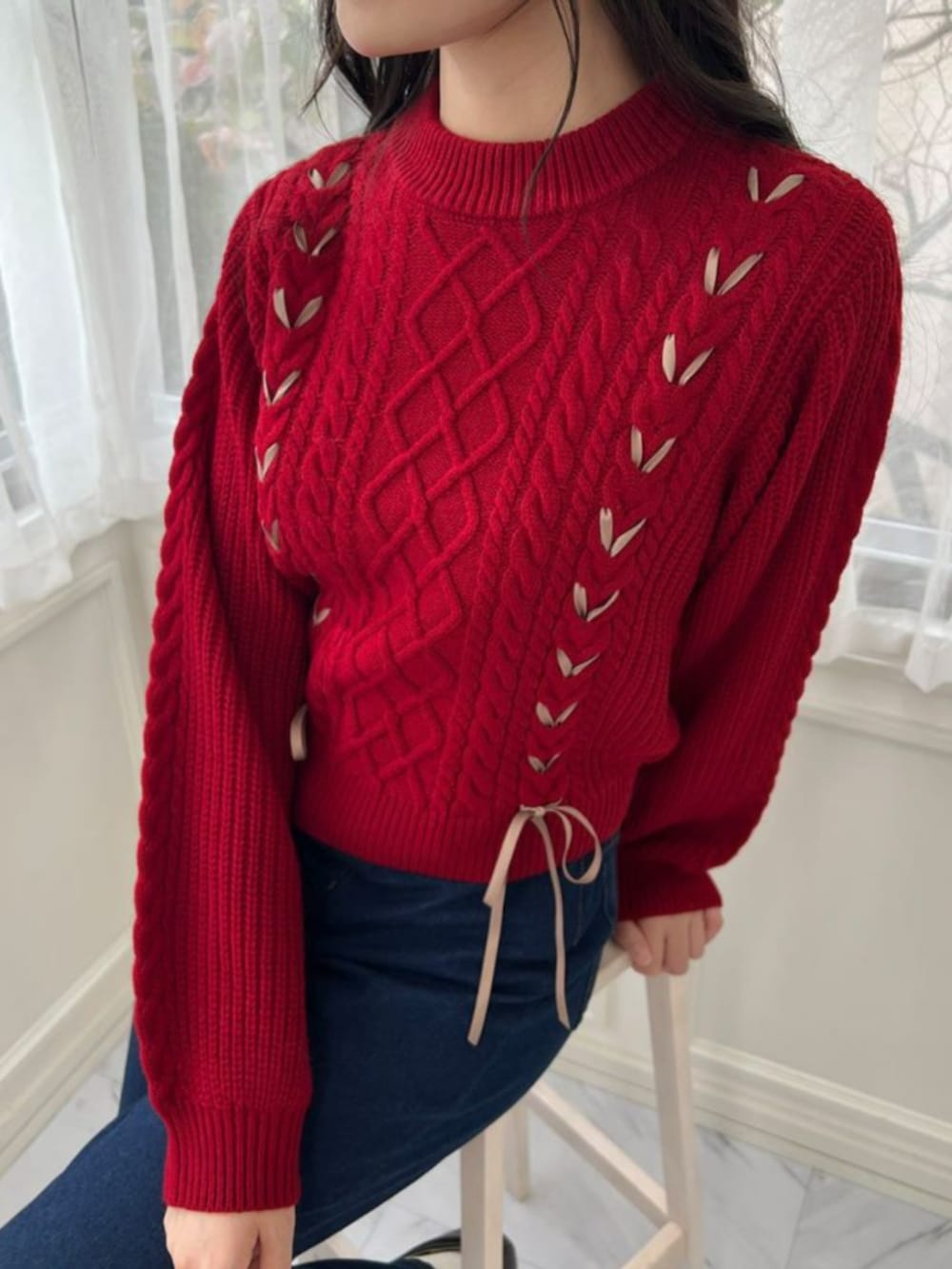 ブラック系のパンプス、ブルー系のデニムパンツ、レッド系のニット/セーターを着用したレディースの秋コーディネートの2枚目の写真