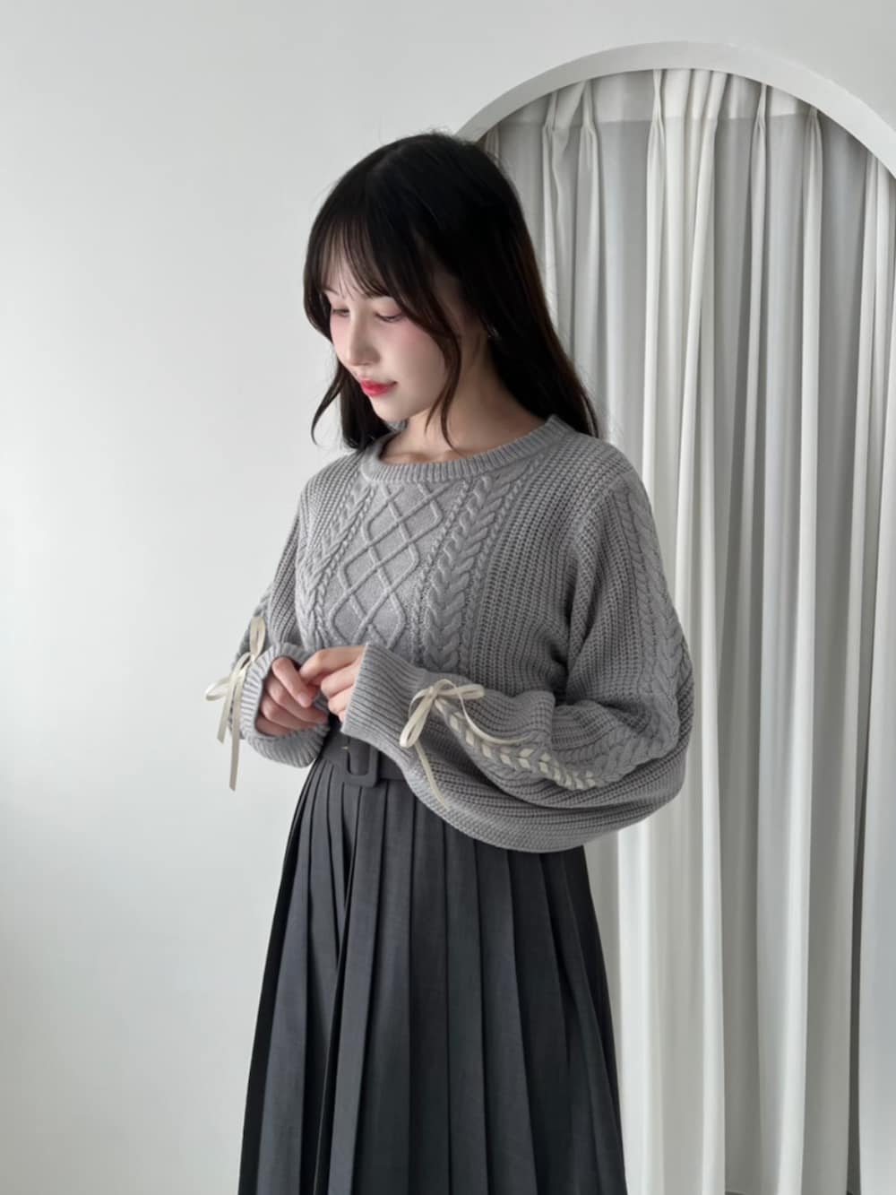 ブラック系のバレエシューズ、グレー系のスカート、グレー系のニット/セーターを着用したレディースの秋コーディネートの2枚目の写真