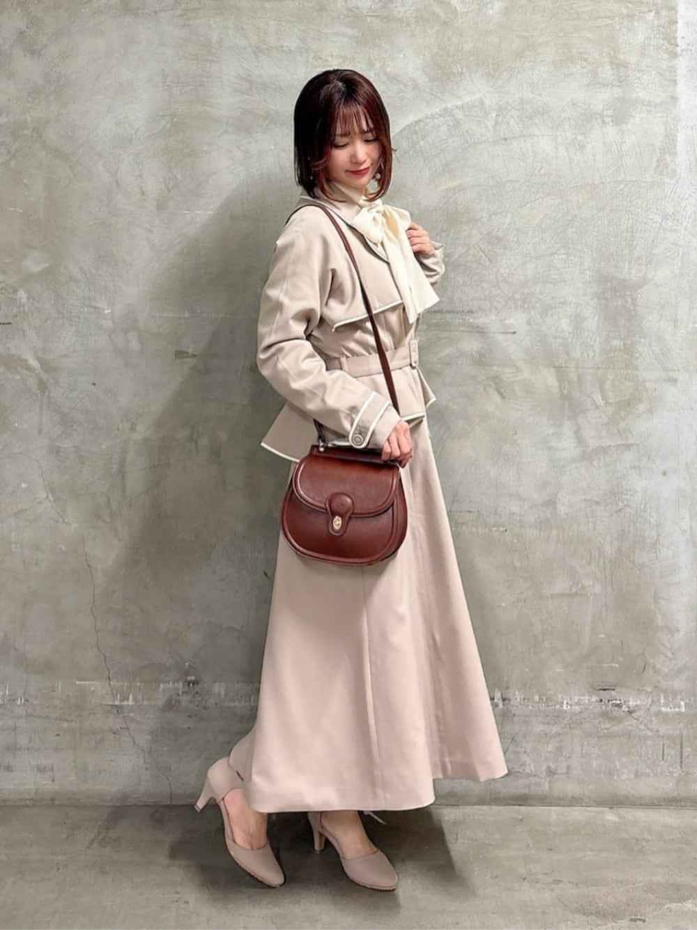 ブラウン系のショルダーバッグ、ピンク系のシャツ/ブラウス、ベージュ系のスカートを着用したレディースの春コーディネートの3枚目の写真