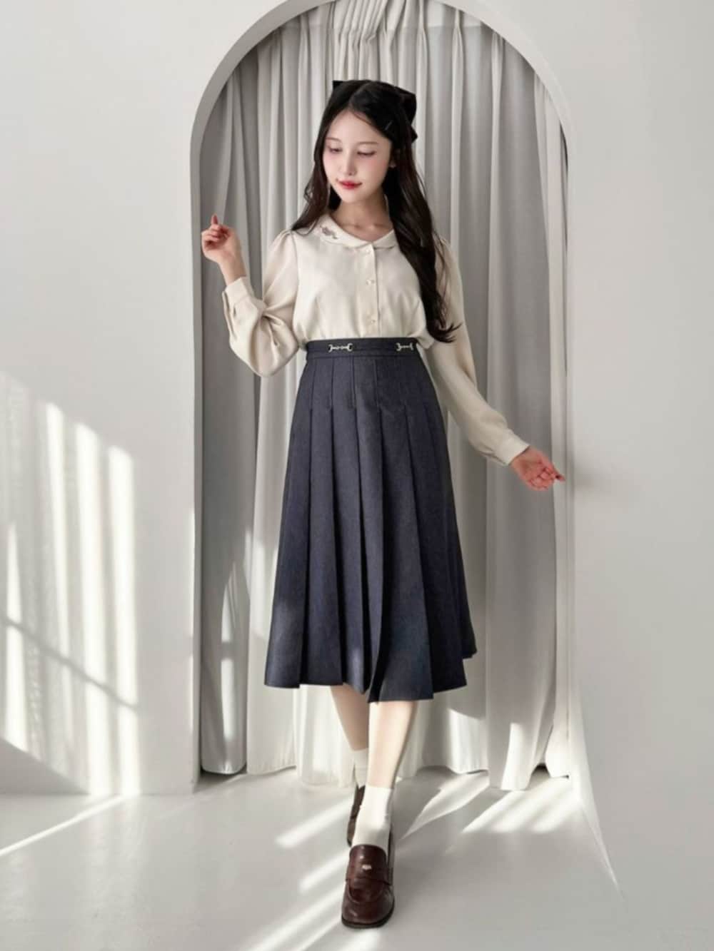 ブラウン系のローファー、ベージュ系のシャツ/ブラウス、ブルー系のデニムスカートを着用したレディースの冬コーディネートの2枚目の写真