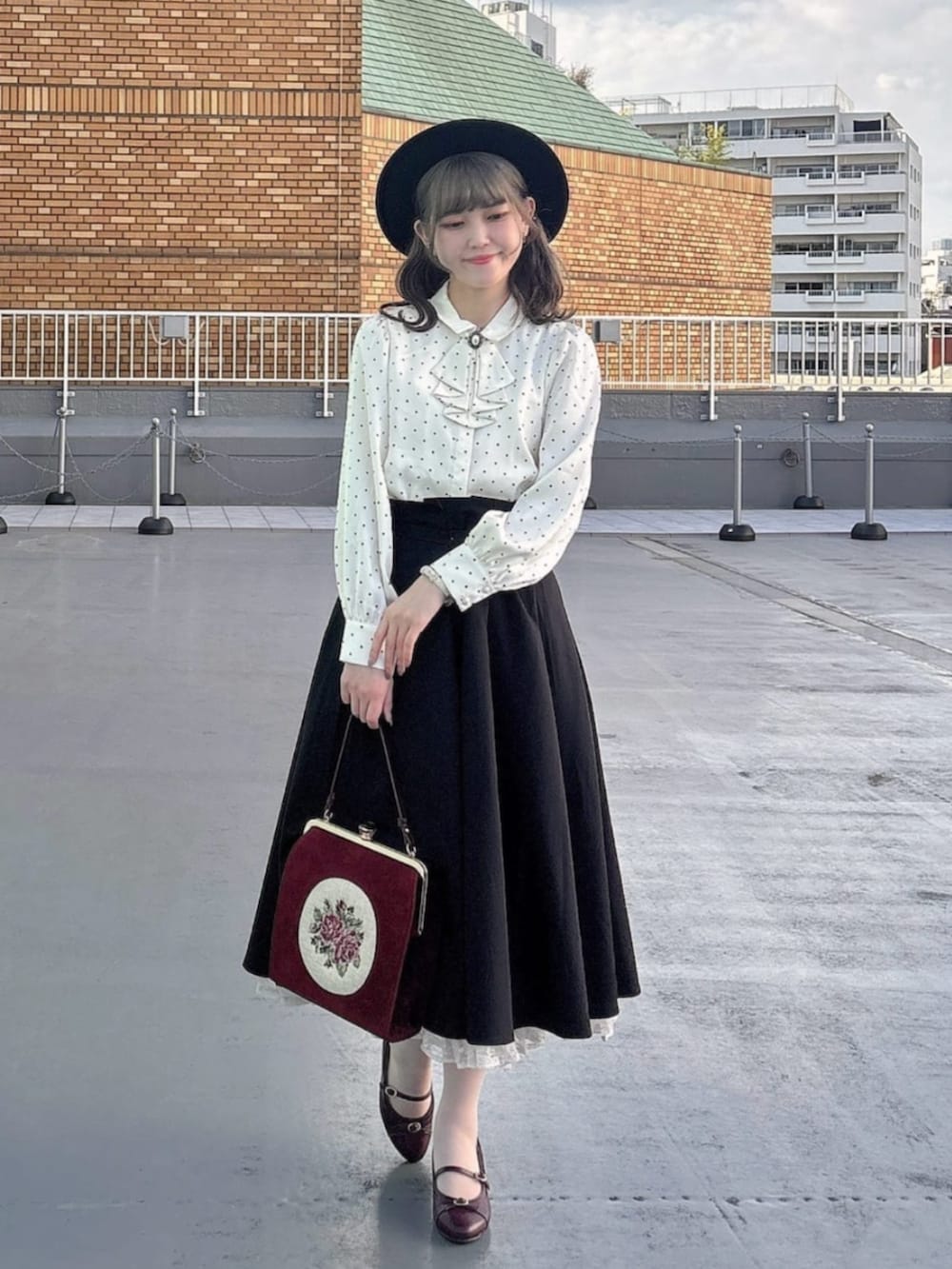 レッド系のパンプス、ホワイト系のシャツ/ブラウス、レッド系のハンドバッグを着用したレディースの秋コーディネートの3枚目の写真