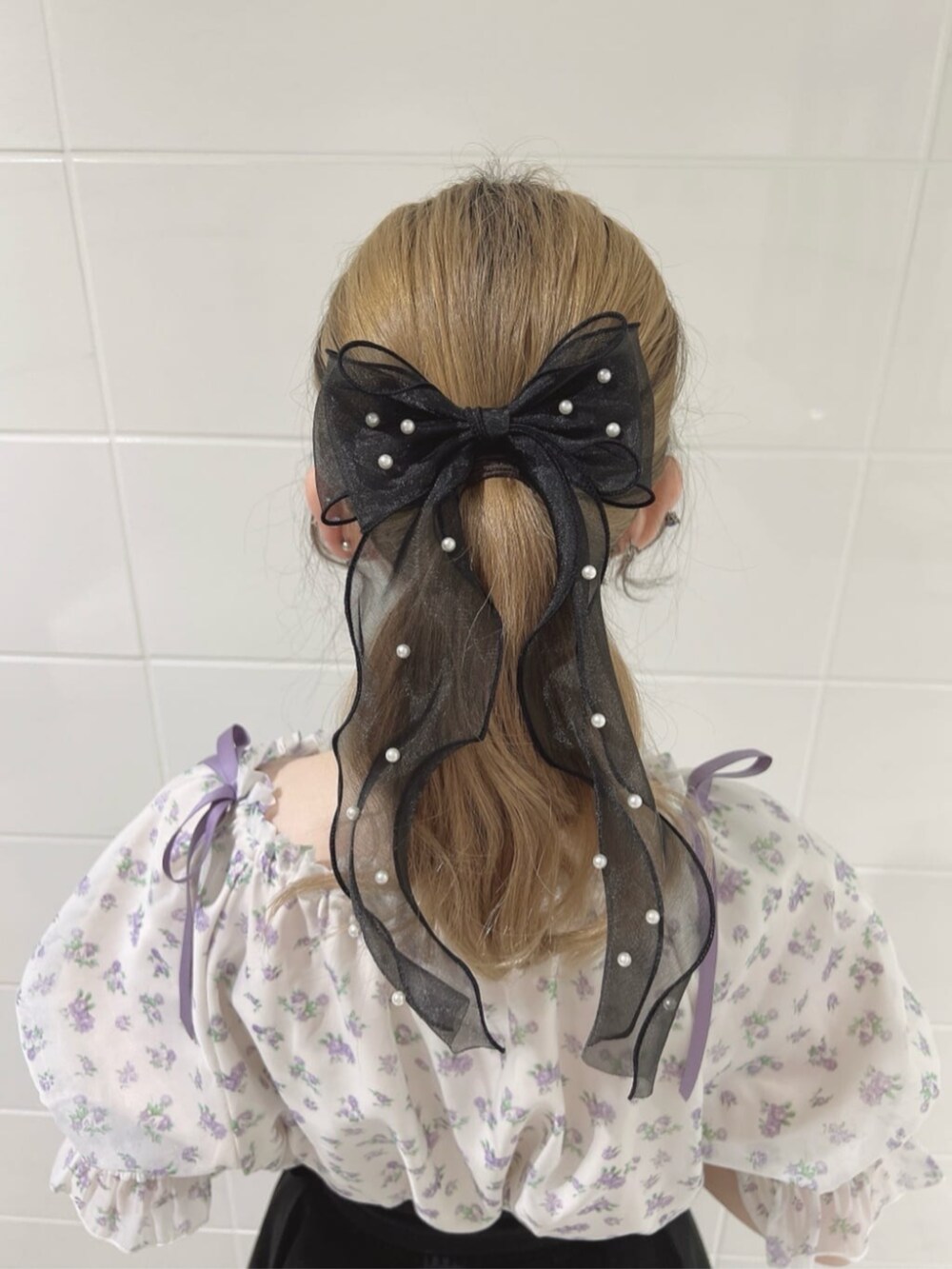 ブラック系のパンプス、ブラック系のスカート、パープル系のシャツ/ブラウスを着用したレディースの春コーディネートの3枚目の写真