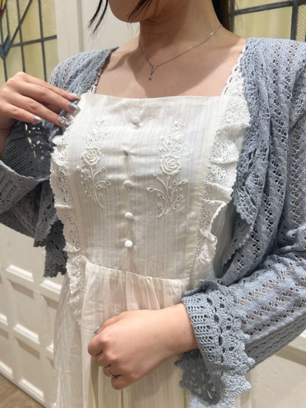 ホワイト系のワンピース、ブルー系のカーディガン/ボレロ、ブラック系のパンプスを着用したレディースの春コーディネートの3枚目の写真