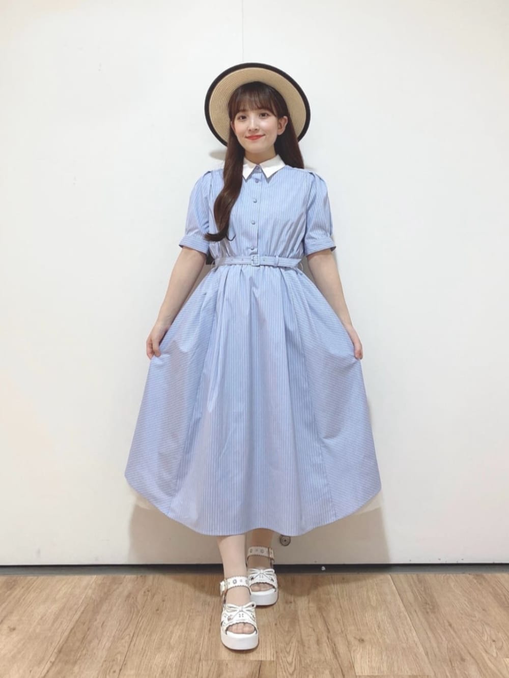 ブルー系のシャツワンピース、ホワイト系のサンダル、ベージュ系のハットを着用したレディースの夏コーディネートの3枚目の写真